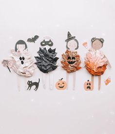 there are five halloween hair clips on the white table with pumpkins and ghost faces