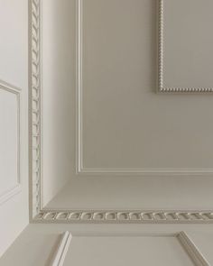 an empty room with white walls and trimmings on the ceiling is pictured in this image