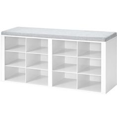 a white bookcase with several compartments and a bench top