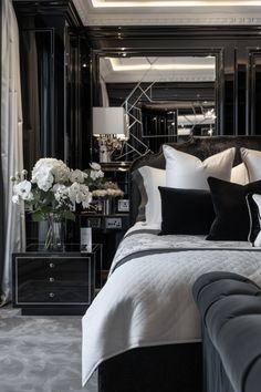 a black and white bedroom with lots of pillows