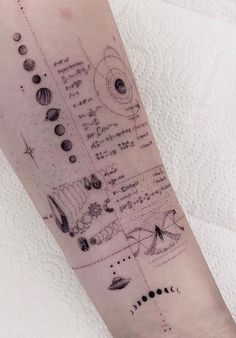 a person with a tattoo on their arm that has planets and stars all over it