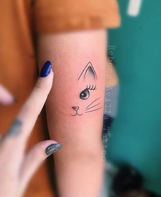 a woman's arm with a cat tattoo on the left side of her arm