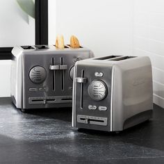 two toasters sitting next to each other on a counter