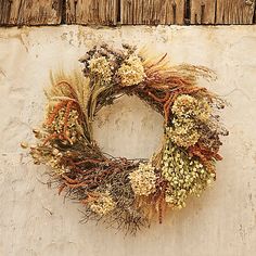 a dried wreath hanging on the side of a building