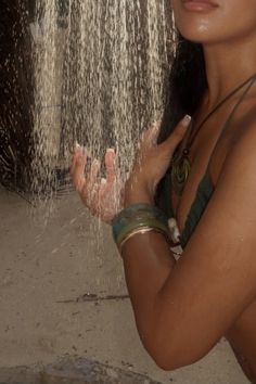 a woman standing in front of a shower head