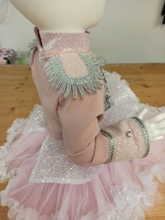 a pink and white ballerina dress with silver sequins on the collar, cuffs, and headband