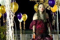 a woman with long hair wearing a dress and balloons