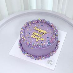 a birthday cake with purple frosting and sprinkles