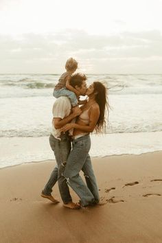 a family walking on the beach holding each other