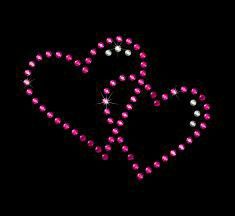 two hearts made out of pink and white beads on a black background with sparkles