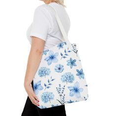 This versatile tote bag is perfect for any occasion - whether you're heading to school, the beach, or the grocery store. Its book bag design makes it easy to carry, while the beautiful blue flowers add a touch of style. Stay eco-friendly with this reusable bag that can be used time and time again. Available in 3 sizes to add both functionality and style, these tote bags come with multiple handle colors to match your designs. Made with spun polyester, these bags feature double-stitched seams, cot Beautiful Blue Flowers, Flowers Tote Bag, Flowers Tote, Bottle Garden, 4th Of July Outfits, Red Strawberry, Coral Peach, Bag Design, Book Bag