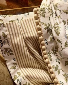 an upholstered chair with striped fabric and pom - poms on it