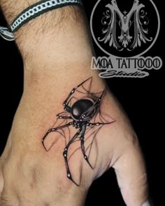 a hand with a tattoo on it that has a black spider crawling out of it