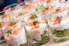 small glasses filled with food sitting on top of a table