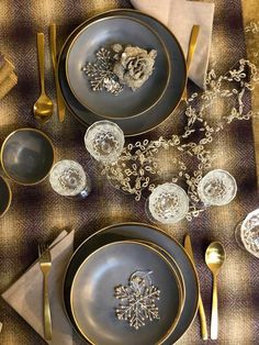 the table is set with silver and gold dishes