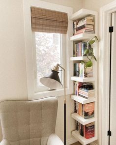 a white chair sitting next to a window filled with books