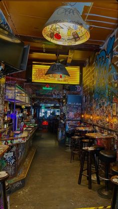 the inside of a bar with many tables and stools