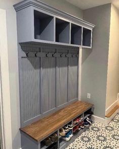 a wooden bench sitting next to a wall filled with shoes