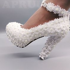 a woman's white high heeled shoes with beading on the toes and heels