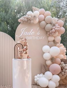 a birthday party with balloons and decorations on the table, including a cake in front of a sign that says jade's birthday