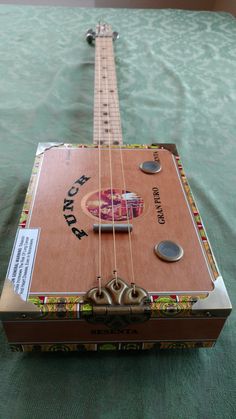 a wooden guitar sitting on top of a green table