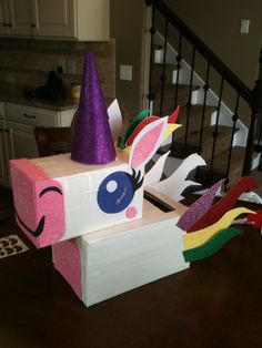 a cardboard box that has some kind of unicorn on top of it, sitting on a table