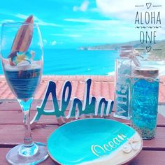 there is a plate and glass on the table with an ocean themed drink in front of it