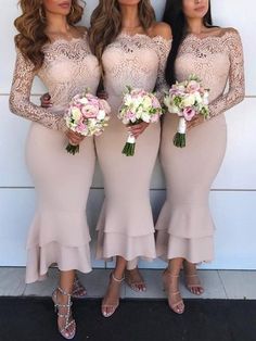 three bridesmaid in long dresses standing next to each other and holding bouquets