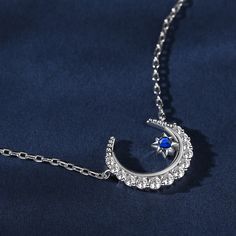 The crescent moon symbolises new beginnings and the ever-changing cycles of life. Crafted in sterling silver, this necklace features a delicate crescent moon and a twinkling blue star. This piece embodies the celestial beauty and the mystical allure of the night sky. Wearing this necklace is like carrying a piece of the night sky close to your heart. It serves as a reminder of the beauty and vastness of the universe, igniting a sense of wonder and inspiration within you.Carat Weight: 0.659 ctSto Elegant Silver Necklace With Sun And Moon Design, Elegant Star-shaped Sun And Moon Necklace, Elegant Sterling Silver Half Moon Necklace, Celestial Moon Shaped Sterling Silver Necklace, Sterling Silver Moon Necklace In Celestial Style, Celestial Moon-shaped Sterling Silver Necklace, Blue Star Jewelry With Moon Charm, Sterling Silver Crescent Clavicle Chain, Dainty Blue Jewelry With Moon Charm