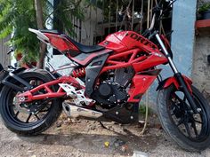 a red motorcycle parked next to a building