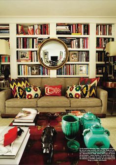 a living room filled with lots of books and furniture