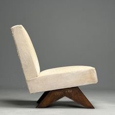 a white chair sitting on top of a wooden base