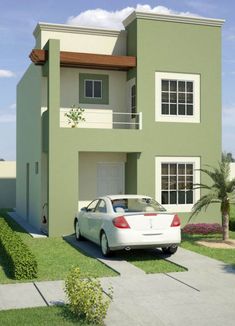 a white car parked in front of a green two story house with balconies