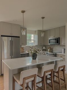 a kitchen with an island and three stools in front of the counter top that has flowers on it