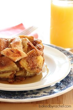 a stack of french toast sitting on top of a plate next to a glass of orange juice