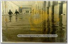 two people are sitting in the middle of an empty hallway with water on the floor