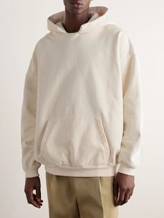 Fear of God takes an effortless approach to everyday style. Modelled after retro, DIY sportswear, this hoodie is made from fleece-back cotton-jersey and has a spliced neckline that's meant to look custom. It's cut for a loose fit and appliquéd with a logo on the hood. Oversized Sportswear Hoodie With Double-lined Hood, Sporty Cream Hooded Hoodie, Cream Hoodie With Drawstring Hood, Sporty Cream Hoodie With Double-lined Hood, Sporty Cream Hoodie With Drawstring Hood, Cream Hoodie Sweatshirt With Drawstring Hood, Oversized Cotton Sportswear Hoodie, Oversized Cotton Hoodie For Sportswear, Oversized Cotton Hoodie In Sportswear Style