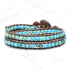 Genuine leather and turquoise Jasper stones make up this classic boho style, double wrap bracelet. Always a favorite for it's versatility and simplicity ~ and when you think bohemian, you think turquoise! Turquoise looks gorgeous on every skin tone. Give it a try and enjoy the versitility. 4mm (.157") diameter turquoise Jasper gemstones Greek cast silver finished button, about 16mm (5/8") in diameter Rust brown leather Signature Bluefish logo heart charm 34 - 39 cm/13.5 - 15.5" length 2 button l Adjustable Bohemian Turquoise Wrap Bracelet, Adjustable Turquoise Bohemian Wrap Bracelet, Turquoise Hand-wrapped Hippie Beaded Bracelets, Bohemian Turquoise Gemstone Beads Wrap Bracelet, Bohemian Turquoise Wrap Bracelet With Gemstone Beads, Earthy Turquoise Bracelets For Festival, Artisan Turquoise Hand Wrapped Wrap Bracelet, Artisan Hand Wrapped Turquoise Wrap Bracelet, Adjustable Turquoise Wrap Bracelet For Festival