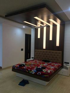 a bed room with a neatly made bed and some lights on the ceiling above it