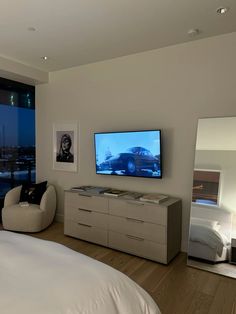 a bedroom with a large flat screen tv on the wall