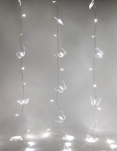 the string lights are hanging from the ceiling in the shape of butterflies and leaves, with white leds on them