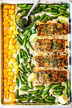 salmon and asparagus on a sheet pan with lemons, green beans, and butter