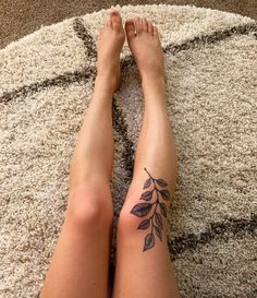 a woman's legs with leaves tattooed on them