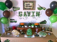 a table topped with lots of green and brown balloons