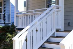 a white stair rail on the side of a house