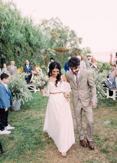 a bride and groom walking down the aisle after their wedding ceremony at an outdoor venue