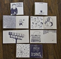 several pieces of paper with drawings and words on them sitting on a table next to each other