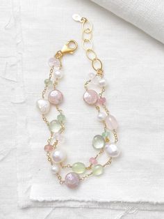 This luxe layered bracelet boasts a lavish combination of pink and green gemstones and freshwater pearls, creating a refined and feminine design. Lobster clasp and extender chain allow for an adjustable fit. Bracelet length:  7.5-8.5 inches Materials:  gold fill, rose quartz, prehnite, tourmaline, mystic moonstone, green amethyst, cultured freshwater pearls GIFTING ~ Jewelry gift box included. ~ I am happy to ship directly to the recipient.  Enter their address during checkout. ~ If you would like a gift note included in the package, please leave the text of the note in the "Add a note to Marsh Creek Jewelry" message box at checkout. FREE SHIPPING ~ Orders ship within 2 business days. ~ Free shipping is First Class ~ Priority Mail and Express Shipping upgrades are available during checkout Elegant Pearl Beaded Bracelets With Gemstones, Elegant Multi-strand Gemstone Beaded Bracelets, Elegant Multi-strand Bracelet With Faceted Beads, Elegant Pink Bracelets With Natural Stones, Elegant Double Strand Bracelets With Gemstone Beads, Elegant Double Strand Gemstone Beads Bracelets, Elegant Double Strand Natural Stones Bracelets, Elegant Double Strand Beaded Bracelets With Faceted Beads, Elegant Double Strand Bracelet With Faceted Beads