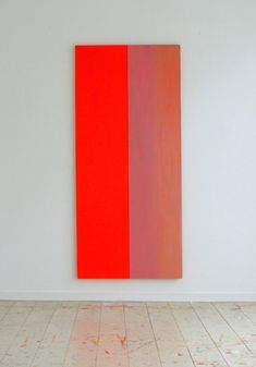 an orange and red painting on a white wall