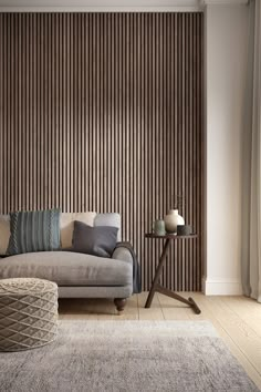 a living room with a couch, table and rugs on the floor in front of a wooden wall